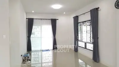 Spacious empty living room with large windows and elegant curtains