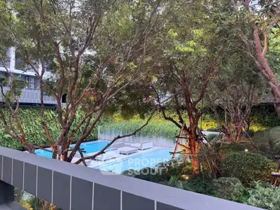 Luxurious residential pool surrounded by lush greenery and modern architecture.