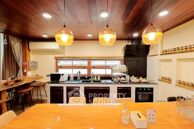 Spacious modern kitchen with wooden ceiling and stylish lighting, featuring open layout and ample counter space.