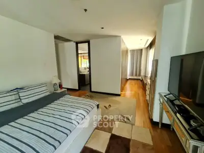 Spacious bedroom with modern decor and natural light, featuring a cozy bed and stylish furnishings.