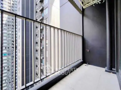 Spacious balcony with modern railing and city view in high-rise building