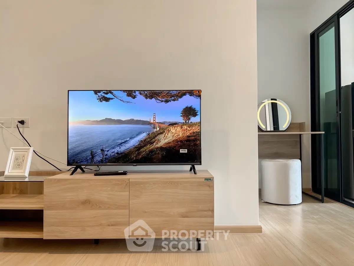 Modern living room with sleek TV setup and stylish vanity area
