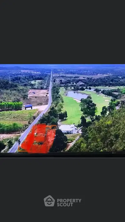Scenic aerial view of expansive green landscape with road and golf course.