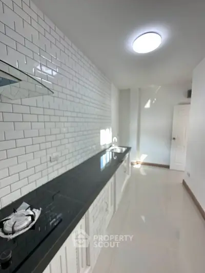 Modern kitchen with sleek black countertops and white subway tile backsplash