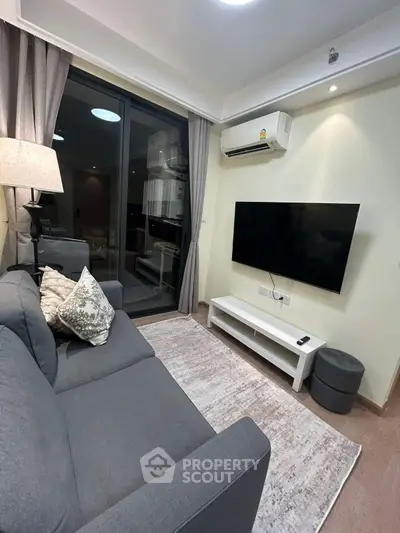 Modern living room with sleek decor, large TV, and cozy sofa, perfect for relaxation and entertainment.