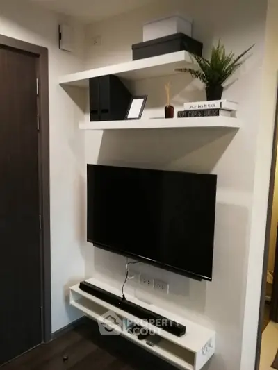 Modern living room with wall-mounted TV and stylish shelves