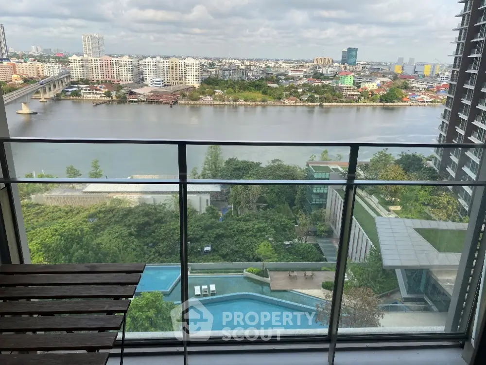 Stunning river view from high-rise balcony with pool and cityscape.