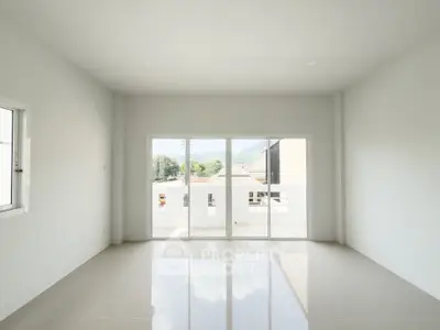 Spacious empty room with large windows and glossy tiled floor, perfect for customization.
