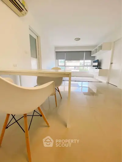 Modern living room with sleek furniture and large windows offering natural light.