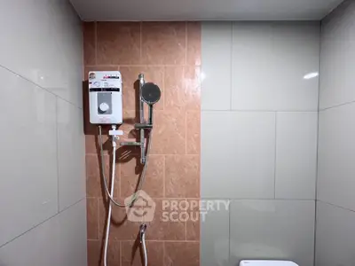 Modern bathroom with sleek shower and water heater, featuring contemporary tile design.