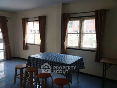 Spacious dining area with natural light and checkered tablecloth, perfect for family gatherings.