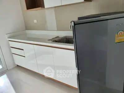Modern kitchen with sleek white cabinets and stainless steel fridge