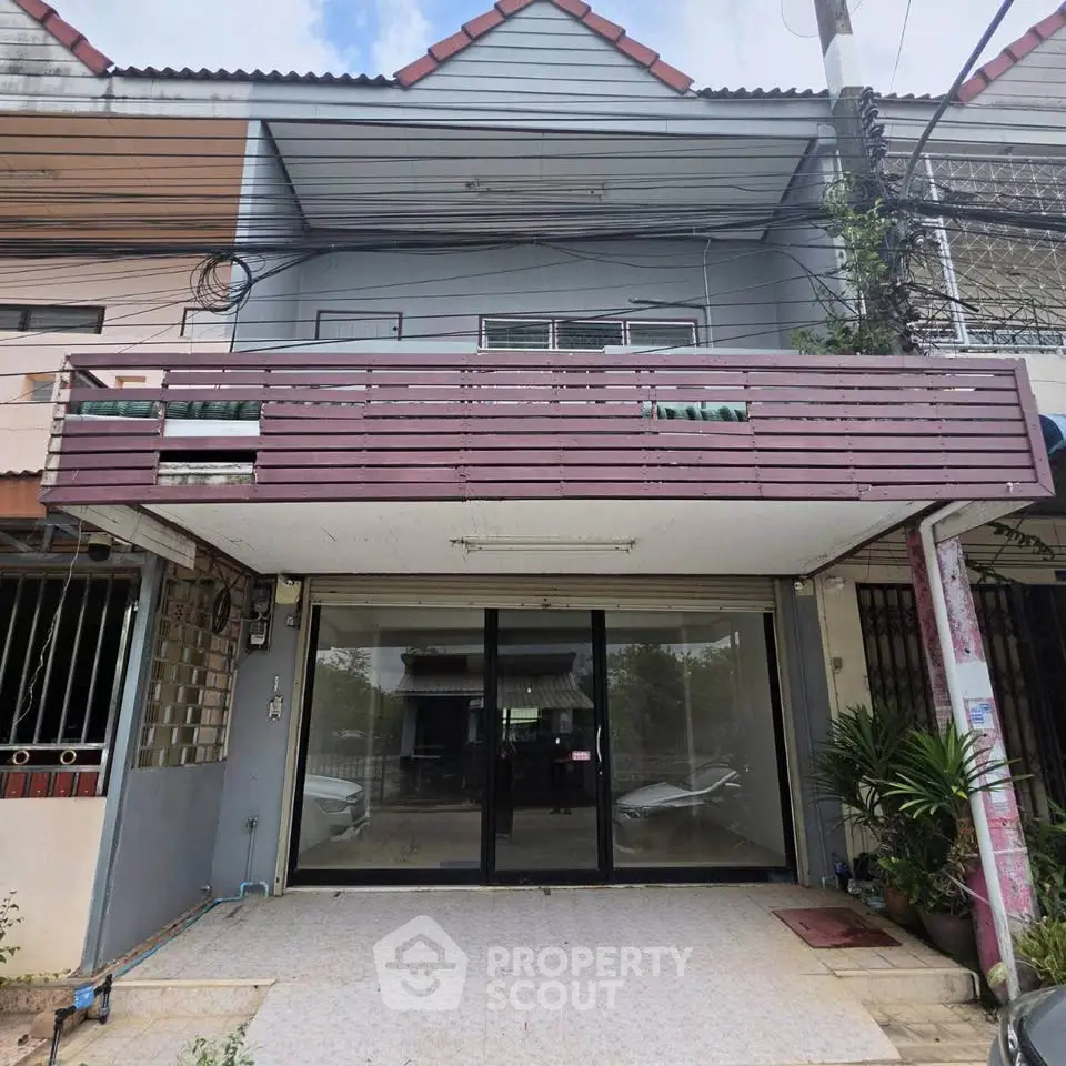 Charming townhouse with spacious balcony and modern glass entrance, perfect for urban living.