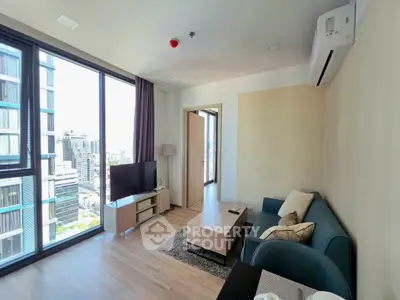 Modern living room with city view, featuring sleek furniture and large windows for natural light.