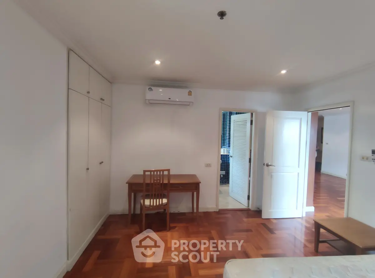 Spacious bedroom with wooden flooring and built-in wardrobe