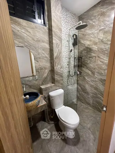 Modern bathroom with stylish tiles and contemporary fixtures in a real estate property.