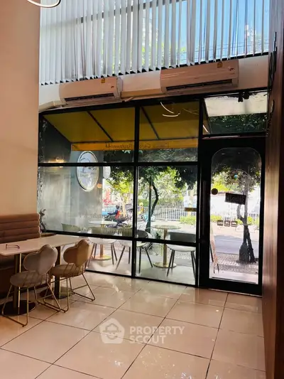 Chic cafe interior with large windows and modern seating, perfect for a cozy urban vibe.