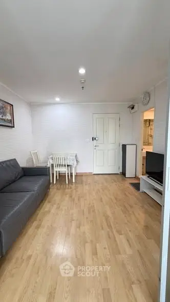 Cozy living room with wooden flooring and modern furniture, ideal for comfortable living.