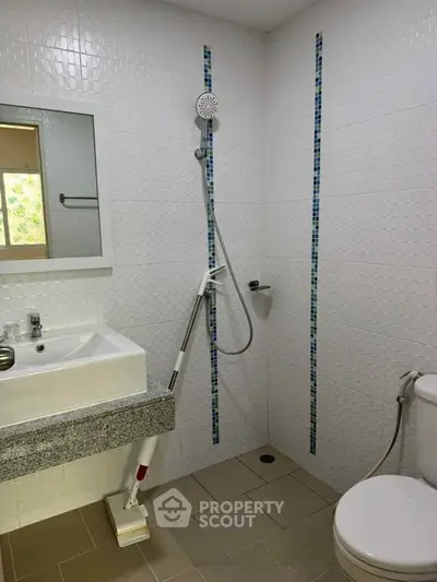 Modern bathroom with sleek shower and elegant sink design.