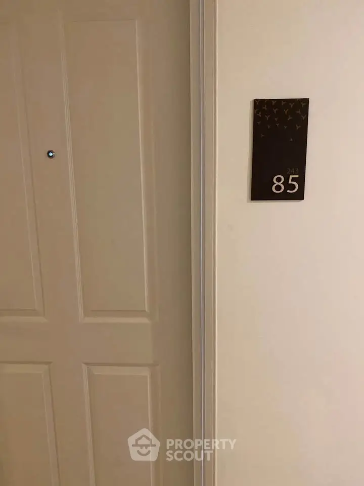 Apartment entrance with door number 85, showcasing a simple and elegant design.