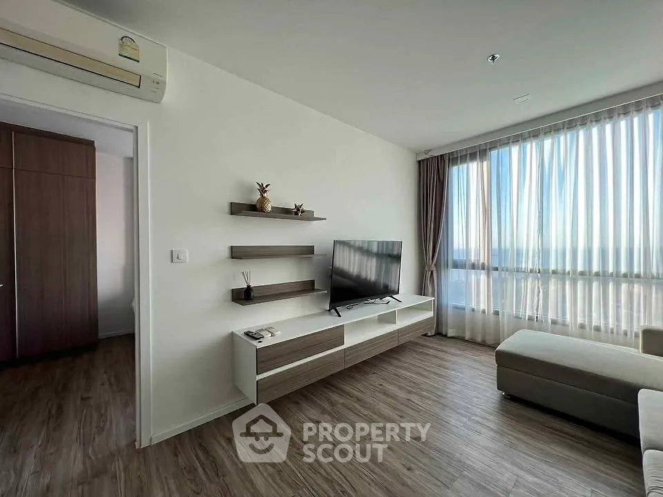 Modern living room with sleek furniture and large window offering stunning views.