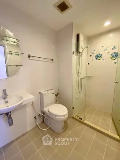 Modern bathroom with glass shower and sleek fixtures in a contemporary apartment.