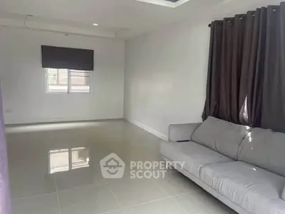 Spacious living room with modern gray sofa and large windows for natural light.