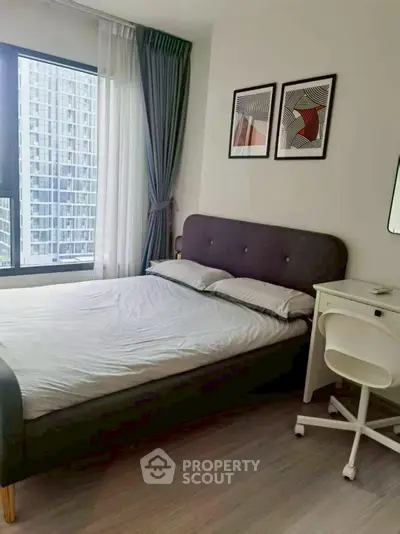 Modern bedroom with stylish decor and large window offering city views, perfect for urban living.