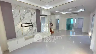 Spacious modern living room with marble accent wall and sleek white cabinetry