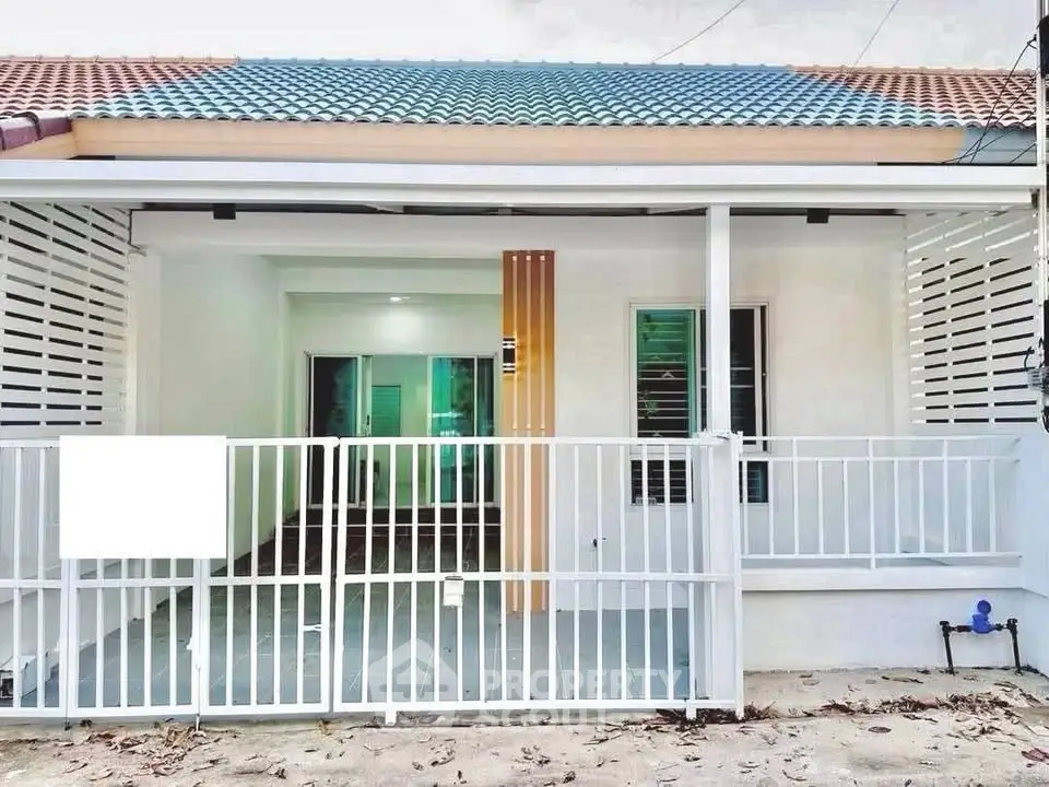 Charming single-story home with modern facade and spacious front patio.