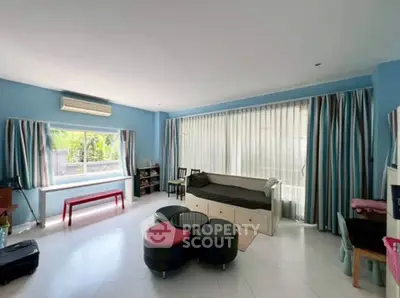 Spacious living room with large windows and modern furniture in a bright, airy setting.