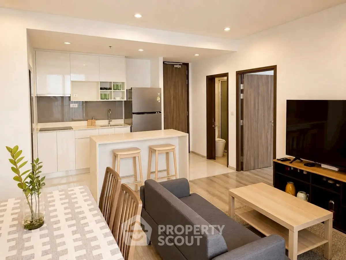 Modern open-plan living room and kitchen with sleek design and neutral tones.