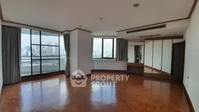 Spacious corner unit with large windows and city view, featuring elegant wooden flooring and mirrored closet.
