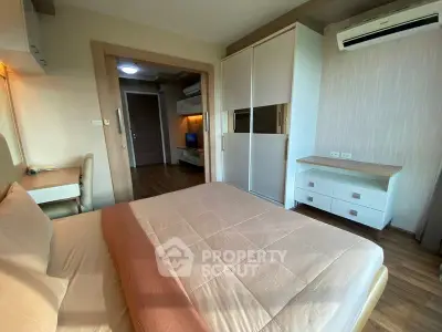 Modern bedroom with wooden flooring and built-in wardrobe in a cozy apartment.