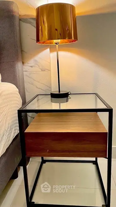 Modern bedroom nightstand with glass top and stylish lamp