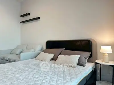 Modern bedroom with cozy bed, stylish lamp, and elegant decor.