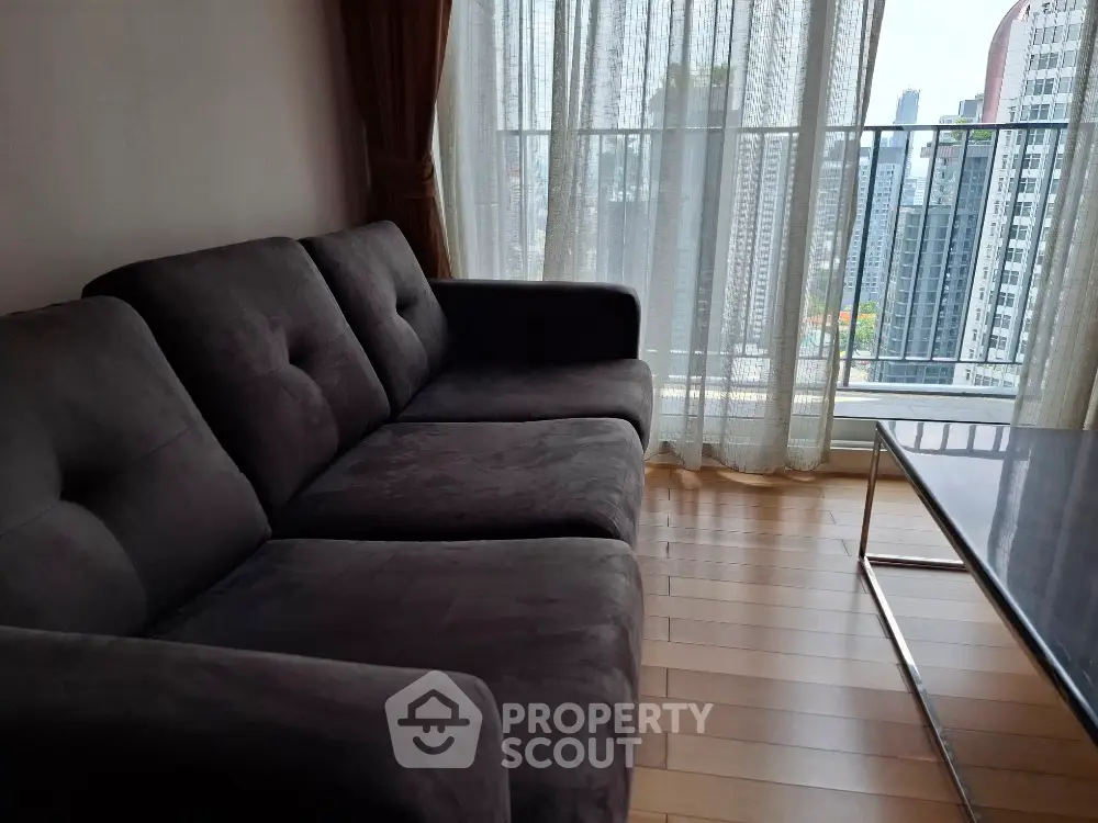 Modern living room with plush sofa and city view from large windows