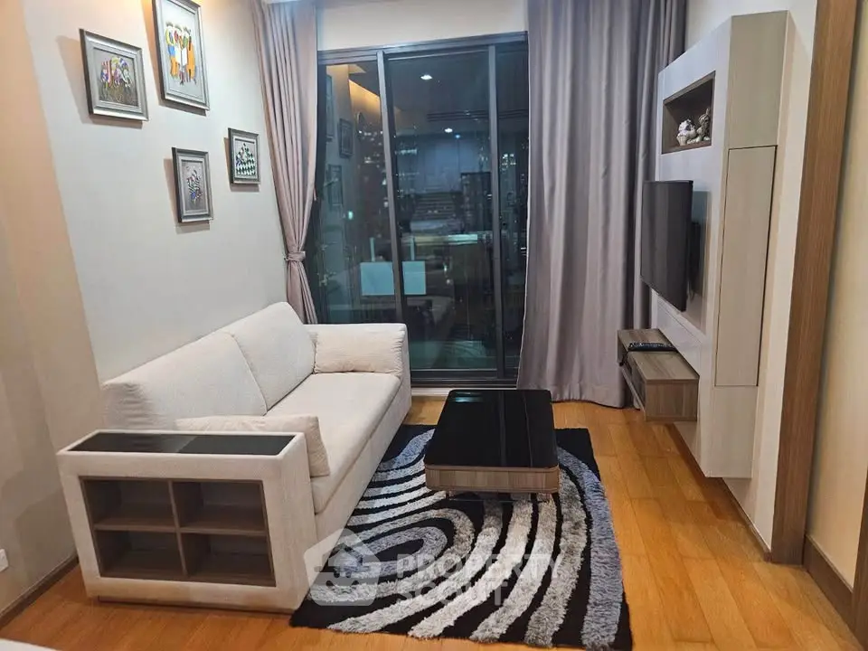 Modern living room with stylish decor and city view balcony, featuring a cozy sofa and contemporary art pieces.