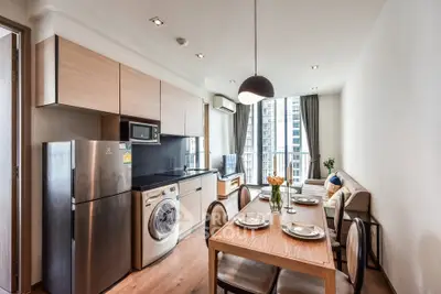 Modern kitchen and dining area with sleek appliances and stylish decor in a high-rise apartment.