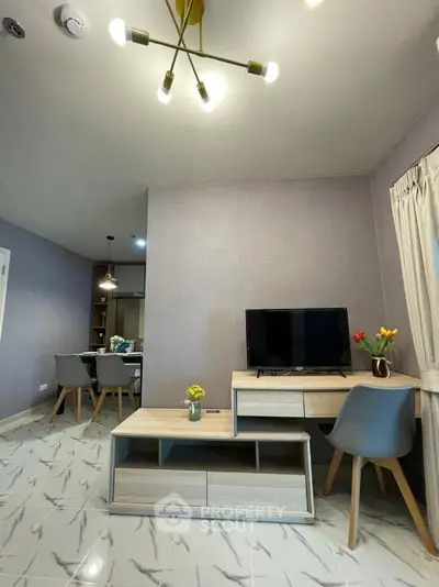 Modern living room with stylish furniture and TV, open dining area, elegant lighting, and chic decor.