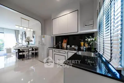 Modern kitchen with sleek design and open layout, featuring a dining area and large windows.