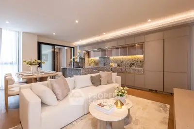 Luxurious open-plan living room with elegant kitchen and dining area, featuring modern decor and ample natural light.