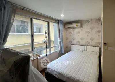 Cozy bedroom with large windows and air conditioning in urban apartment