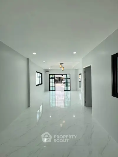 Spacious modern living room with sleek marble flooring and large windows for natural light.