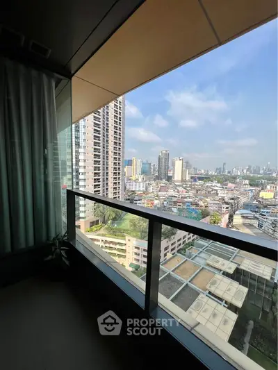 Stunning cityscape view from a modern high-rise balcony with glass railing.