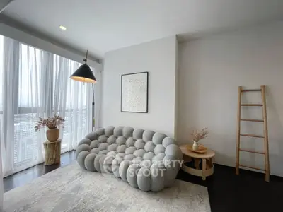 Stylish modern living room with unique sofa and floor-to-ceiling windows