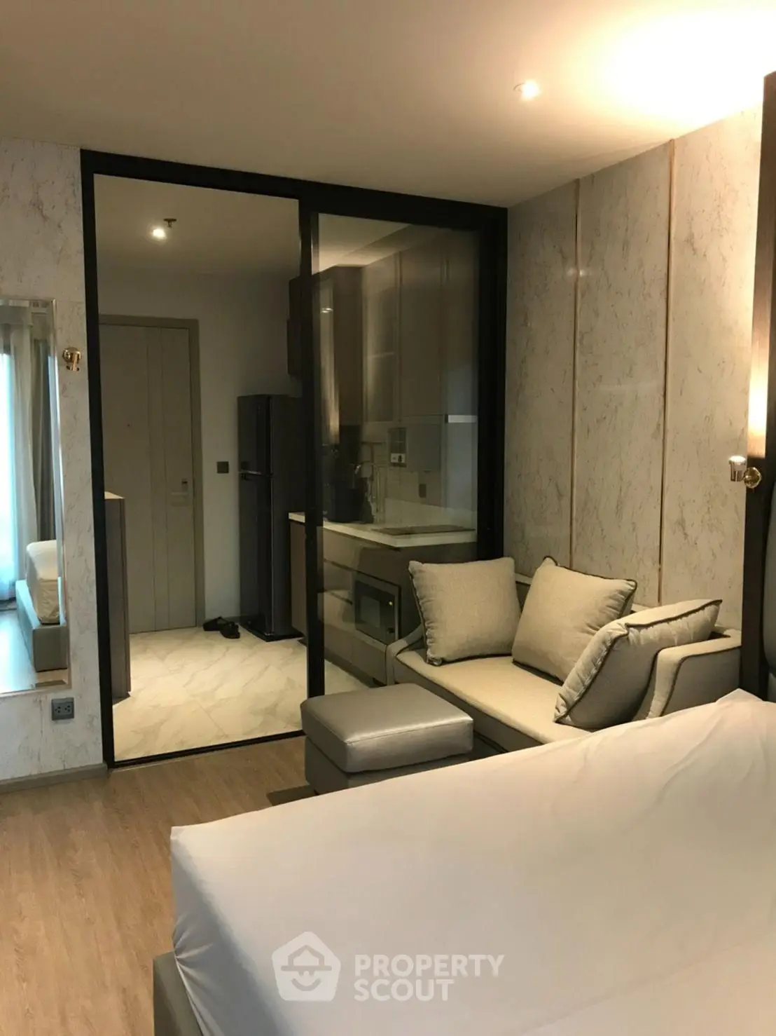 Modern studio apartment with sleek kitchen and cozy living area, featuring elegant marble accents and contemporary design.