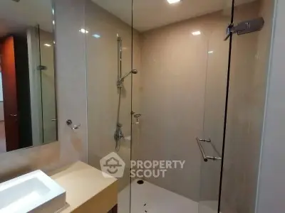 Modern bathroom with glass shower enclosure and sleek vanity.