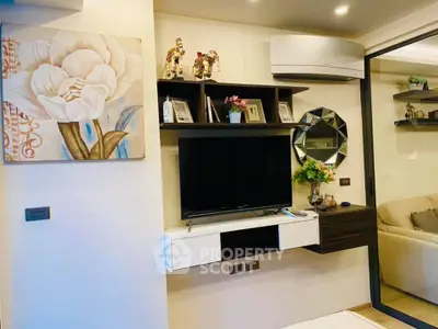 Modern living room with stylish decor, wall-mounted TV, and elegant shelving in a cozy apartment.
