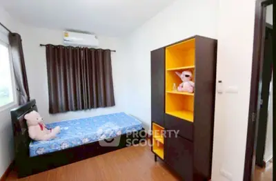 Cozy bedroom with single bed and vibrant yellow shelving unit, perfect for a child's room.